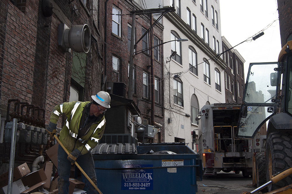 A construction worker toils in an alley