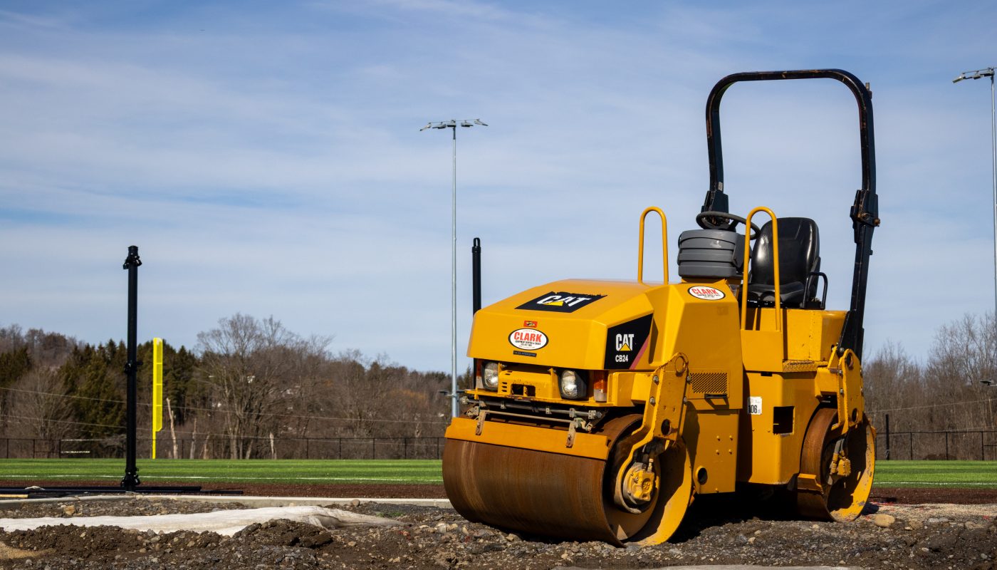 a construction roaller next to the baseball feld under construction