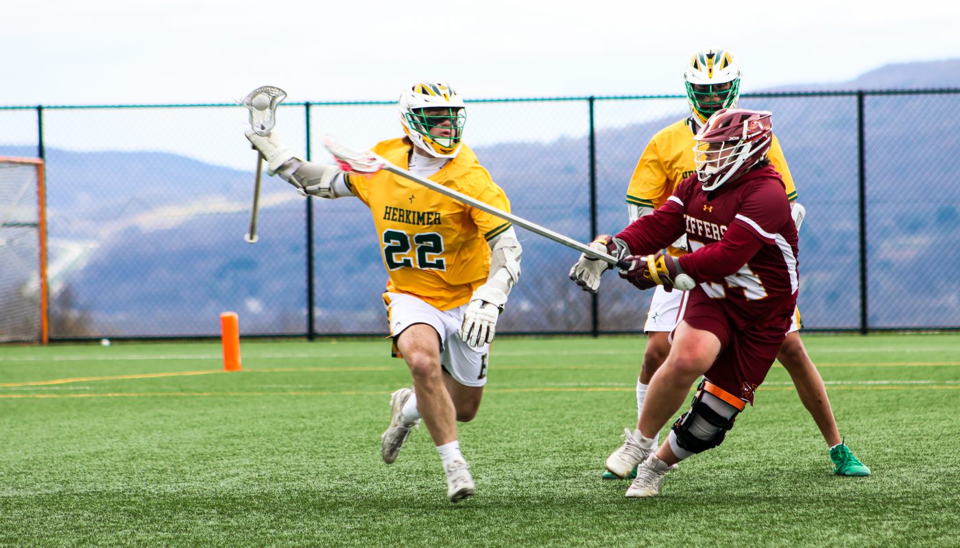 Lacrosse players on field competing for ball