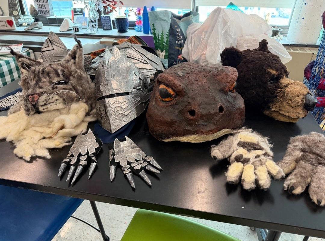 Hand-made masks and other costuming on a table.