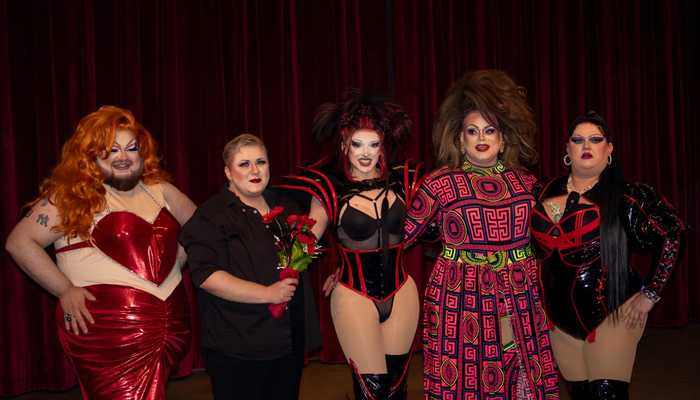 Group photo of drag show performers on stage