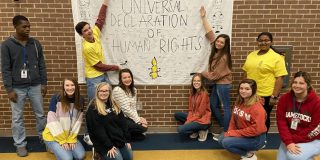 Students pose with banner