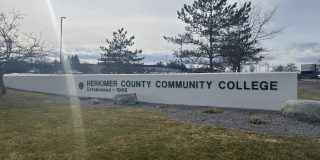Landscape photo of the Herkimer County Community College sigh in front of the school.
