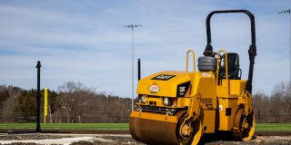 a construction roaller next to the baseball feld under construction