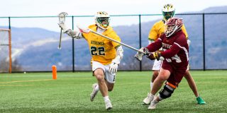 Lacrosse players on field competing for ball