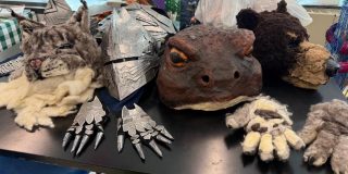 Hand-made masks and other costuming on a table.
